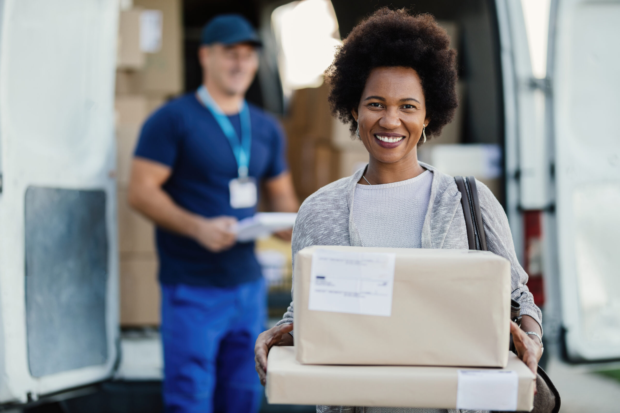 Portrait of satisfied woman holding her delivered packages.